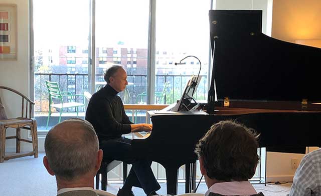 chris pouliot playing piano while people watch